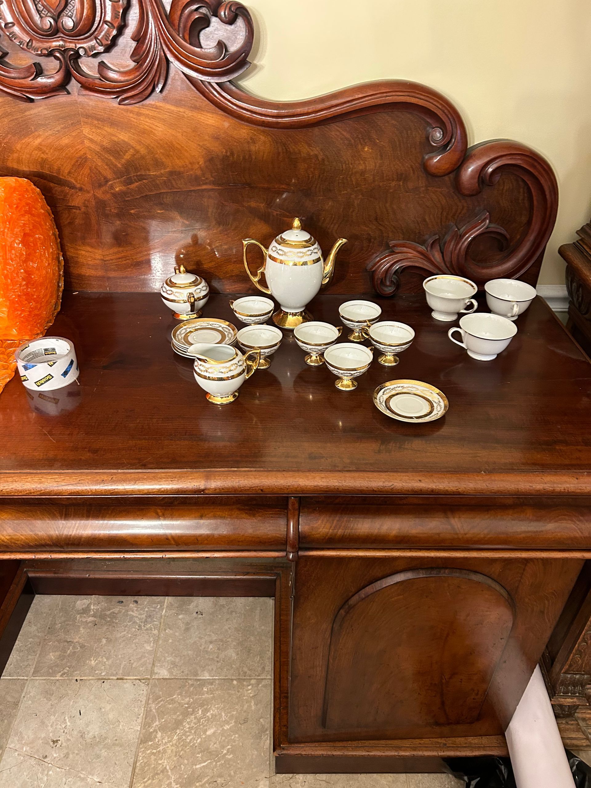 A wooden table with a tea set on it.