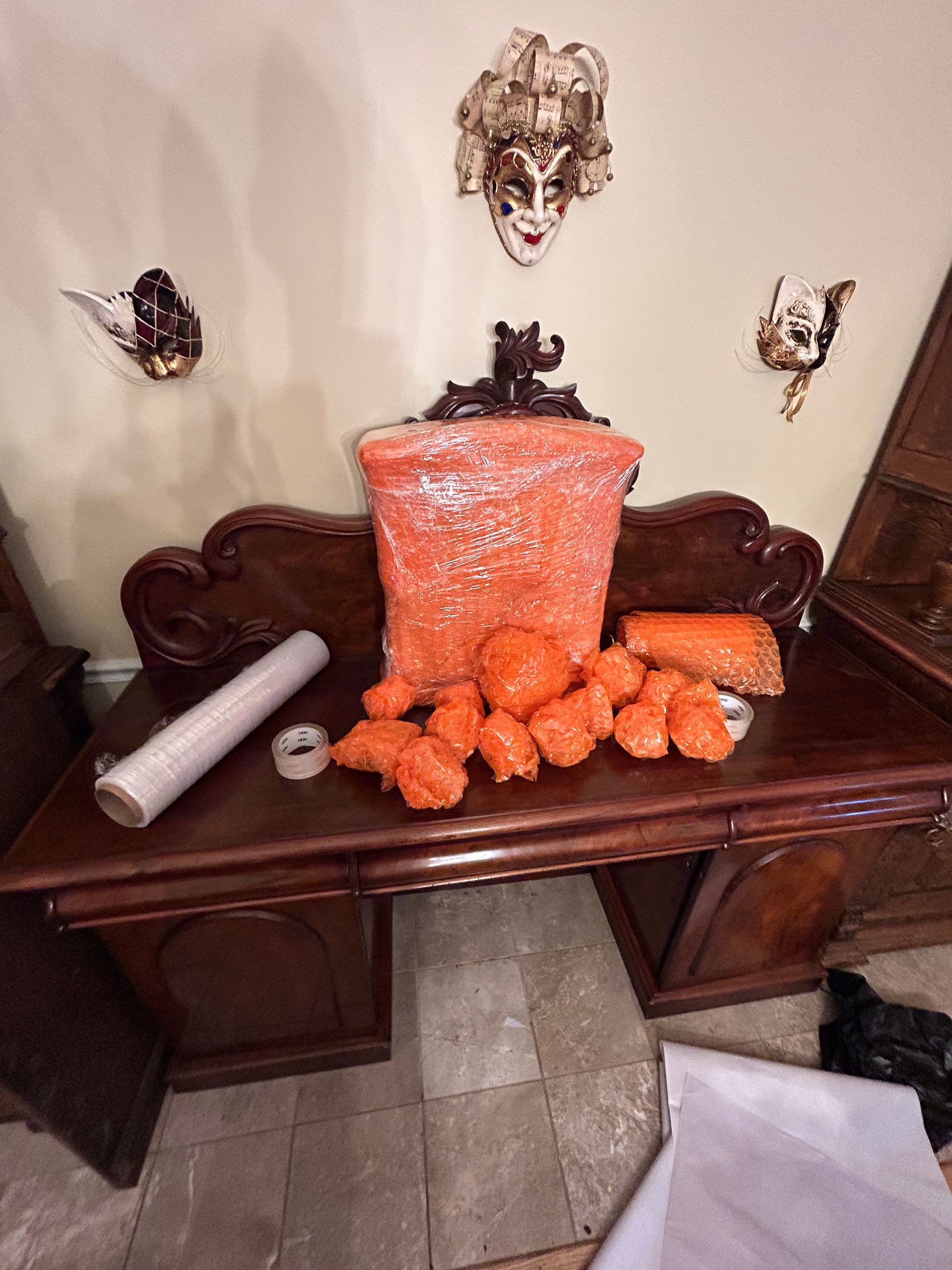 A wooden desk with a bag of orange beads on it.