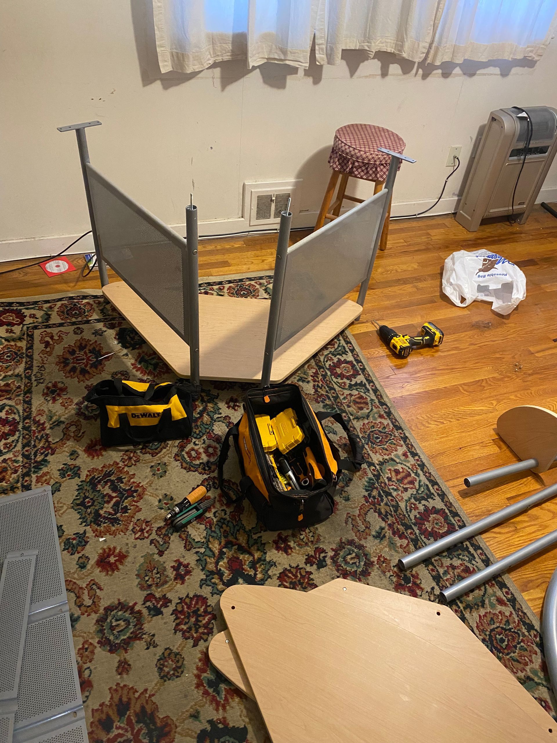 A chair is being built in a living room with tools on the floor.