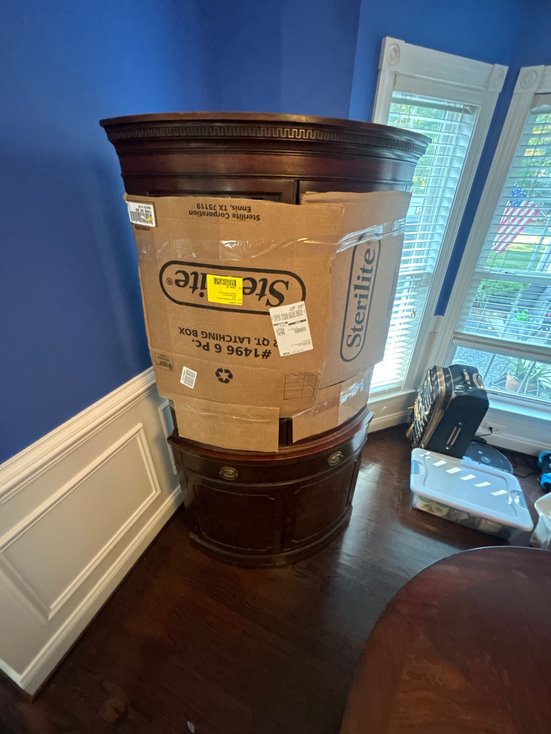 A stack of cardboard boxes sitting on top of a wooden table in a living room.