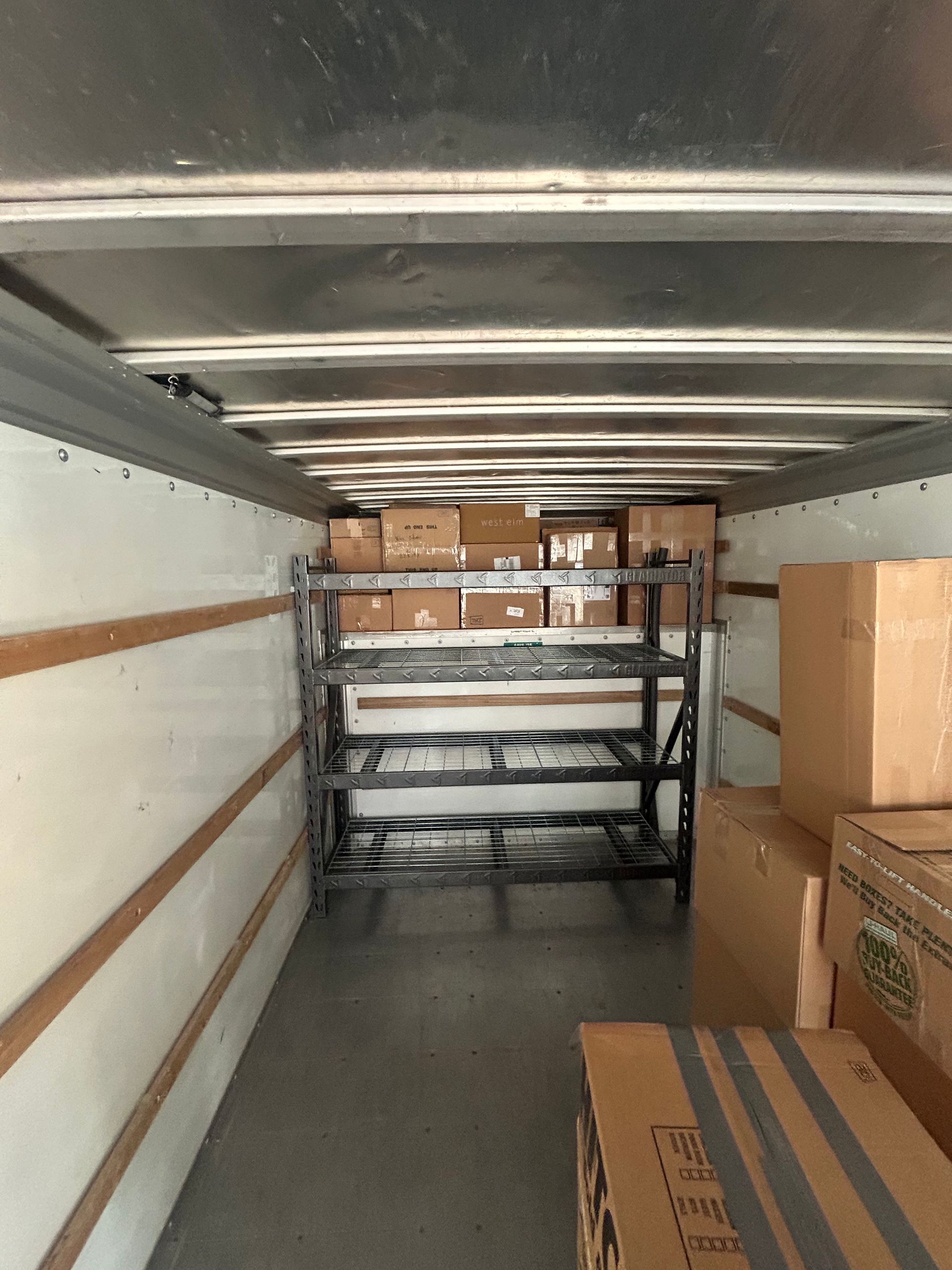 The inside of a truck filled with boxes and shelves