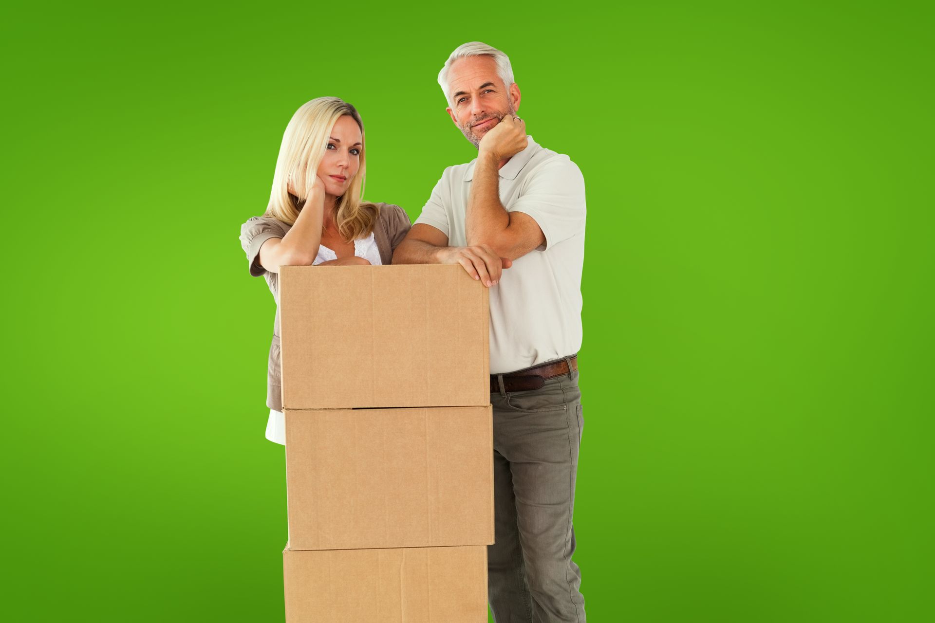 A man and a woman are standing next to a stack of cardboard boxes.