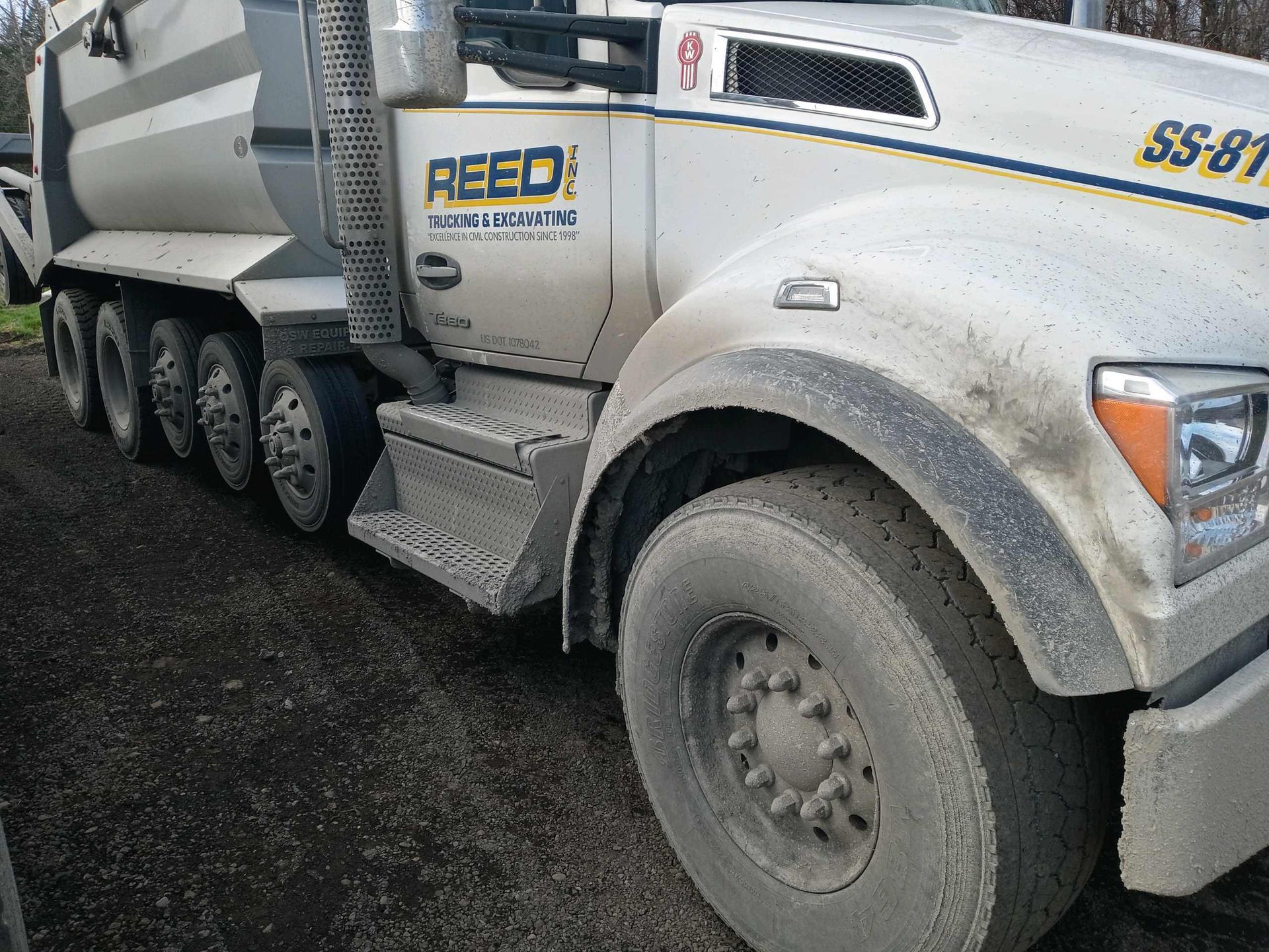 Dirty white concrete truck parked on a dark surface.