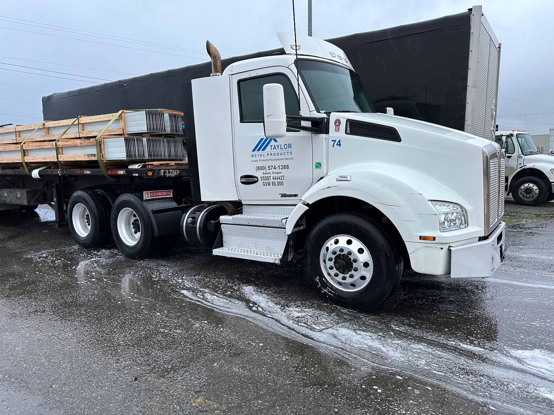 A man is washing a truck with a high pressure washer.