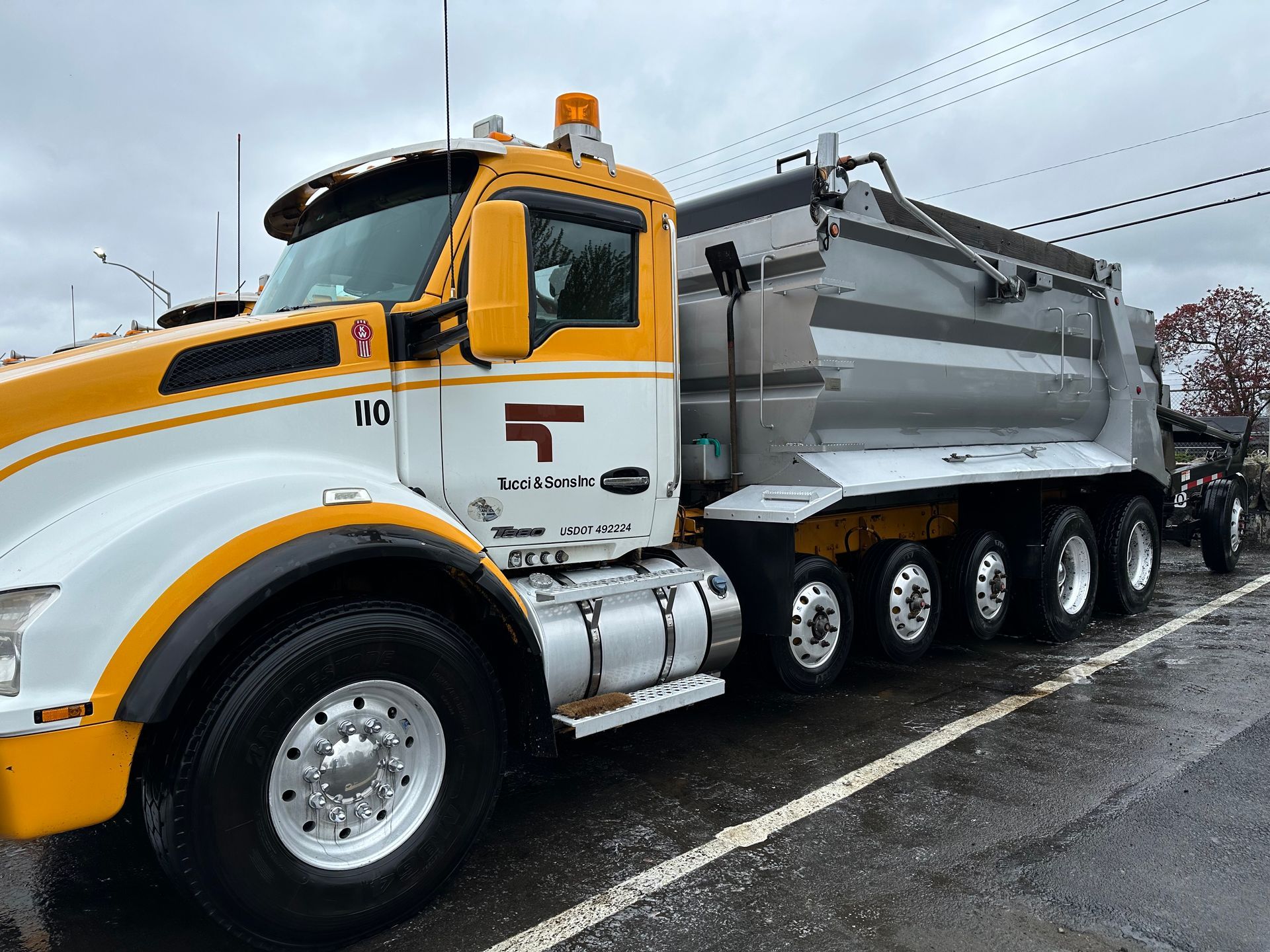 A man is washing a truck with a high pressure washer.