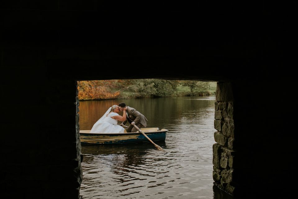 Bride and groom kissing on a sailing boat on a lake