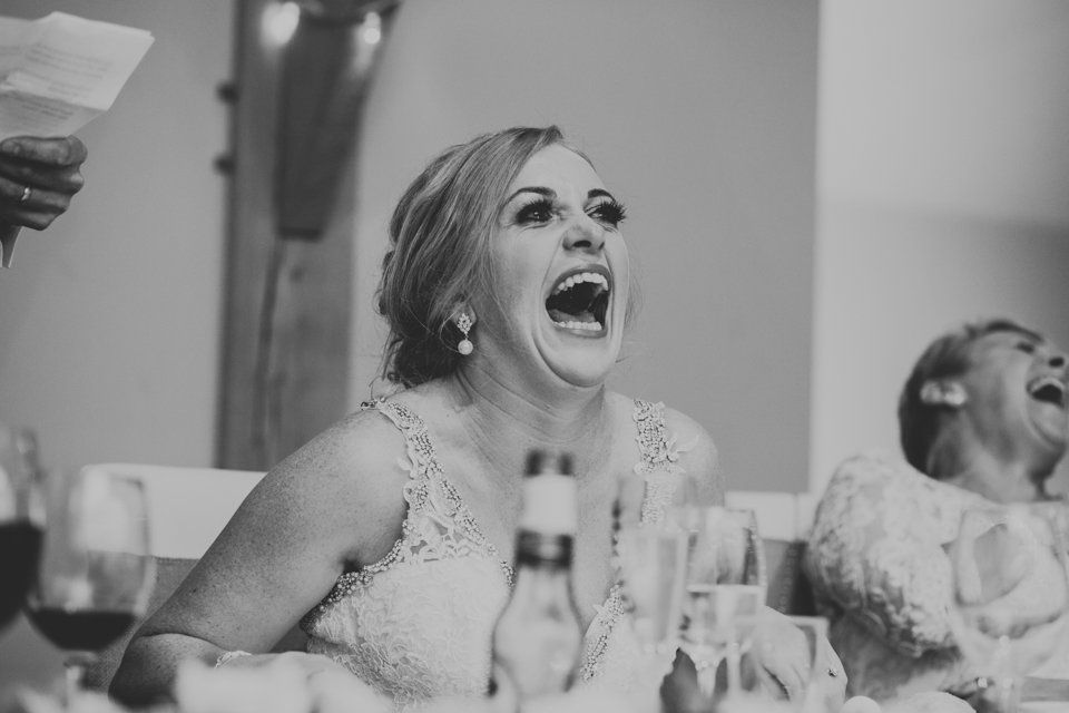 black and white wedding photograph of the bride laughing