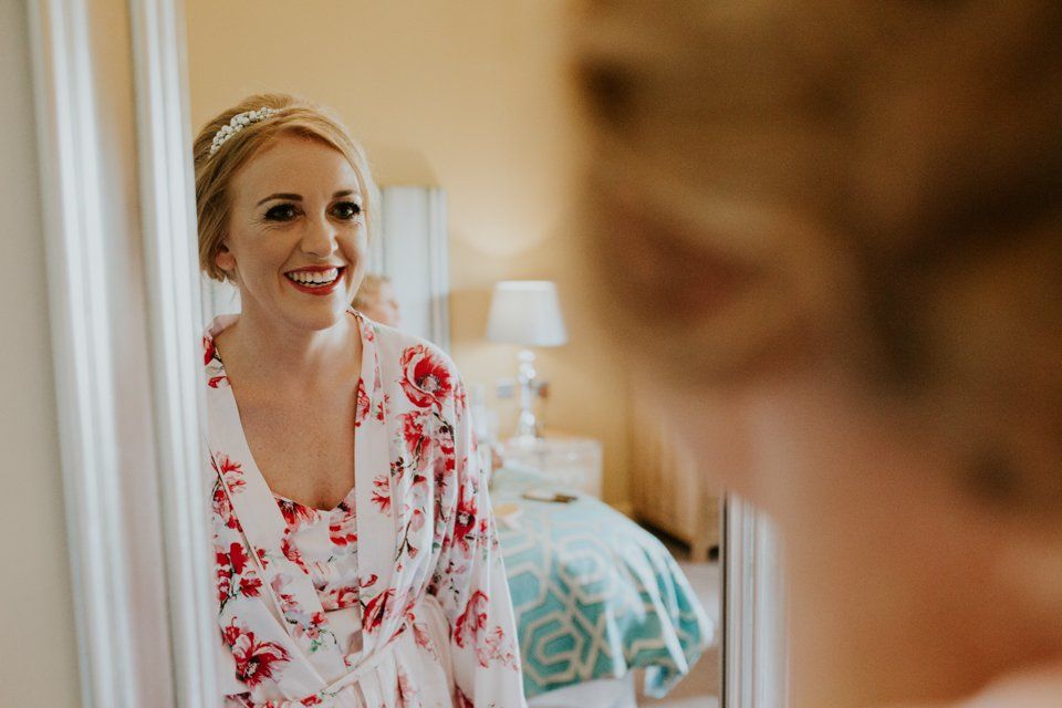 bride looking in the mirror at her make up before her wedding