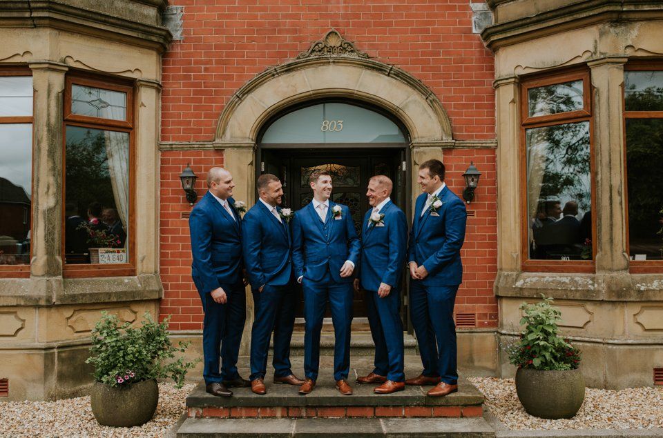 groomsmen standing together laughing for a wedding group photograph