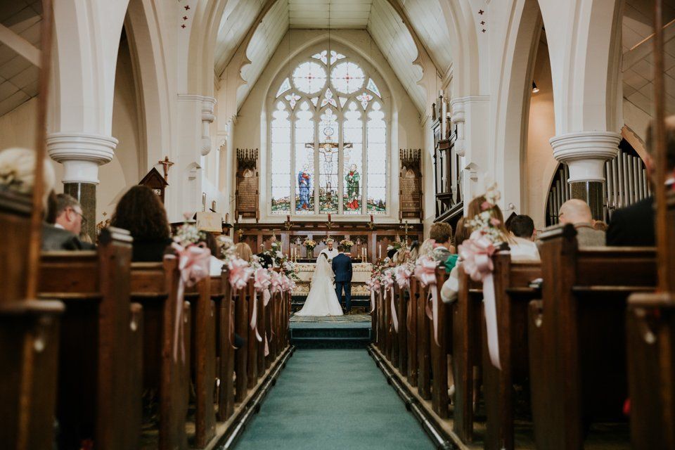 photograoh from the back of a church service showing bride and groom getting married