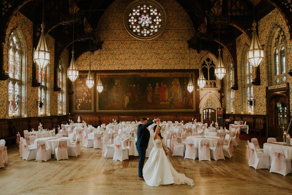 bride and groom dancing in a grand hall
