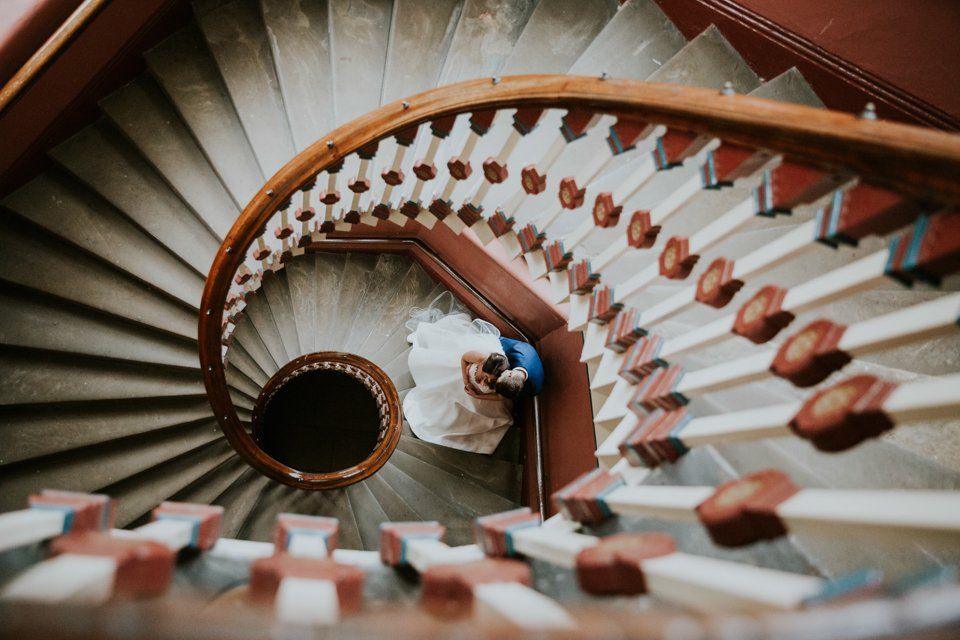 bride and groom posing fro a photograph on a spiral staircase
