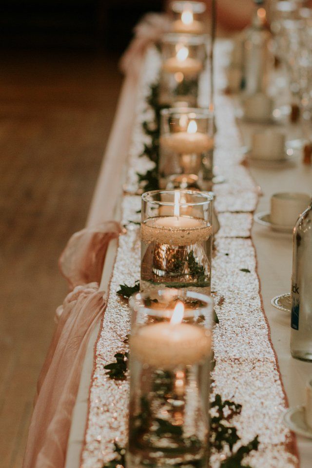 wedding table decoration with tea lights floating on water in vases