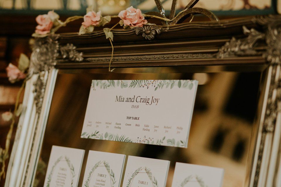 table plan for wedding guests with names printed on cards and stuck to a mirror