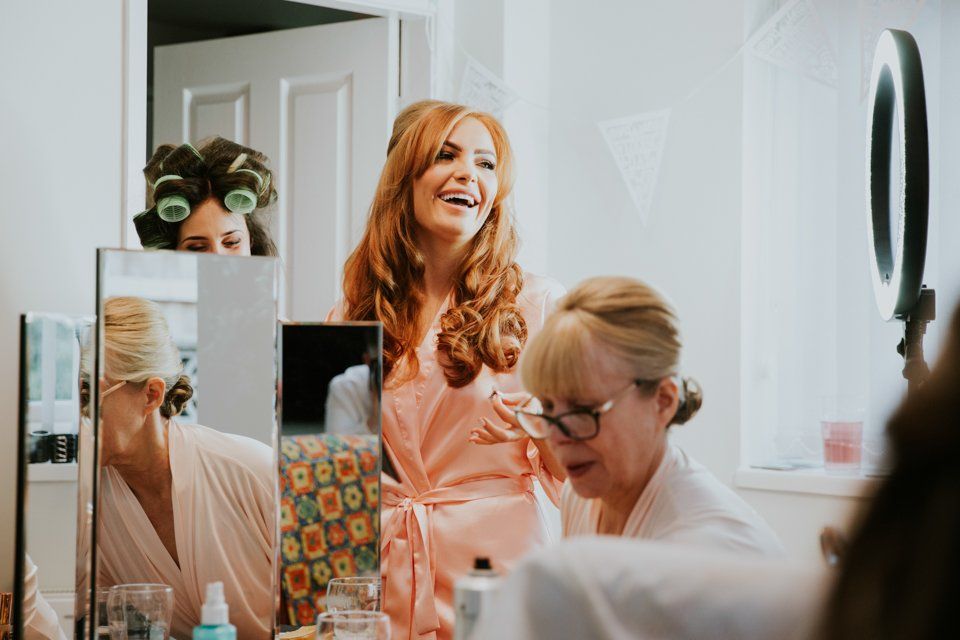bridesmaid laughing whilst getting ready before a wedding 