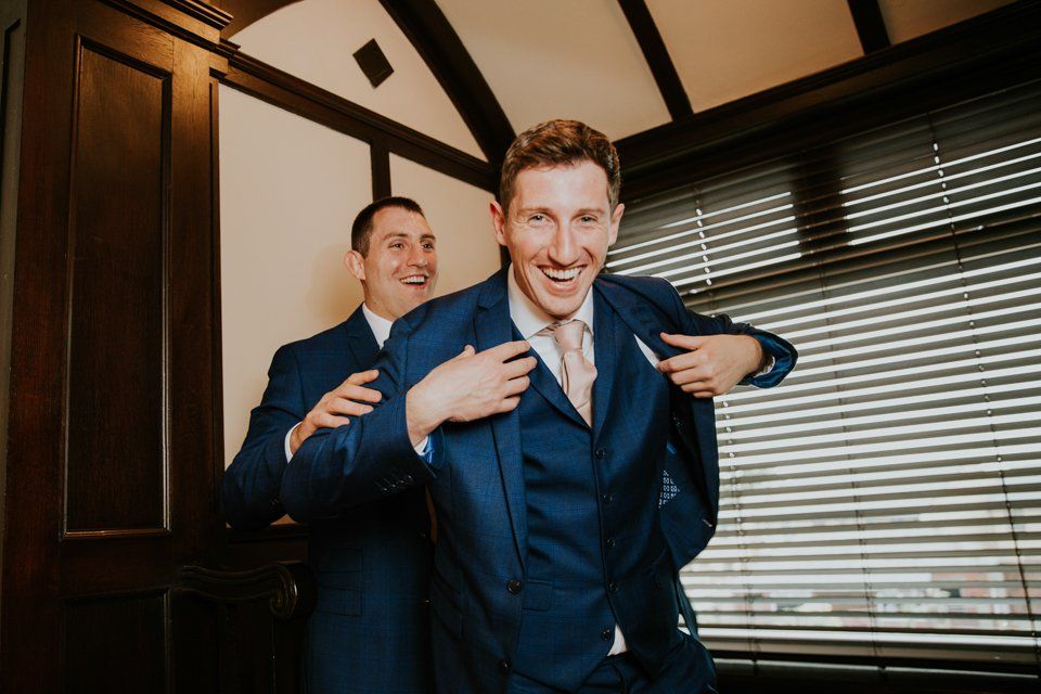 groom and bestman putting their jackets on to leave for a wedding