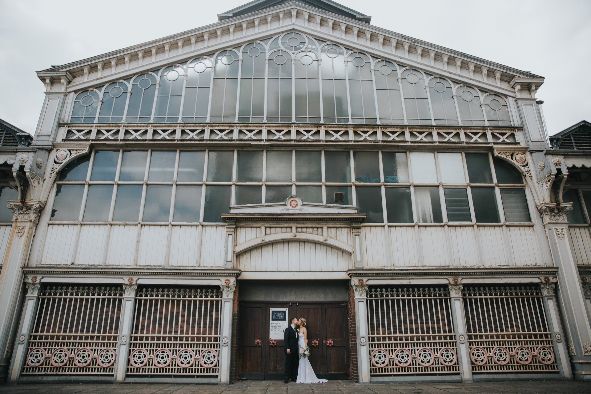 Bride and groom kissing in front of old manchester city centre building