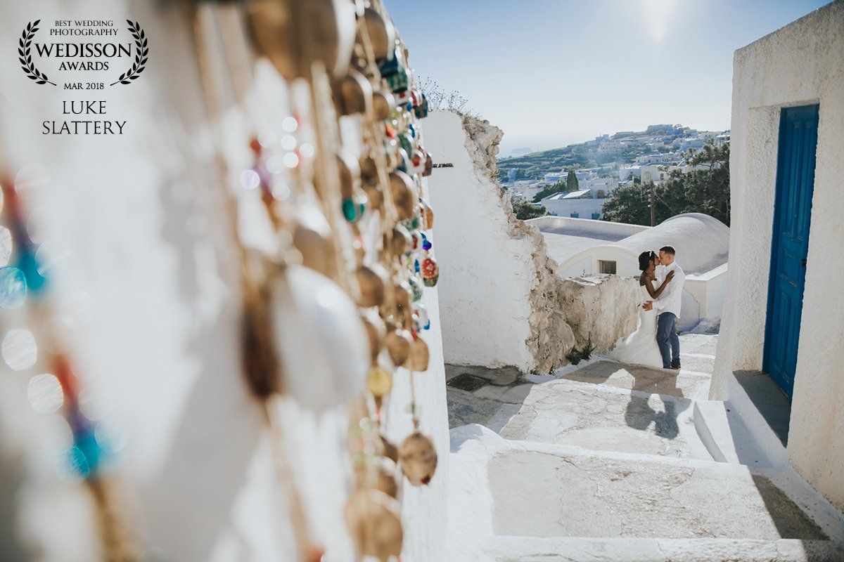 Bride and Groom kissing on steps at destination wedding in Santorini
