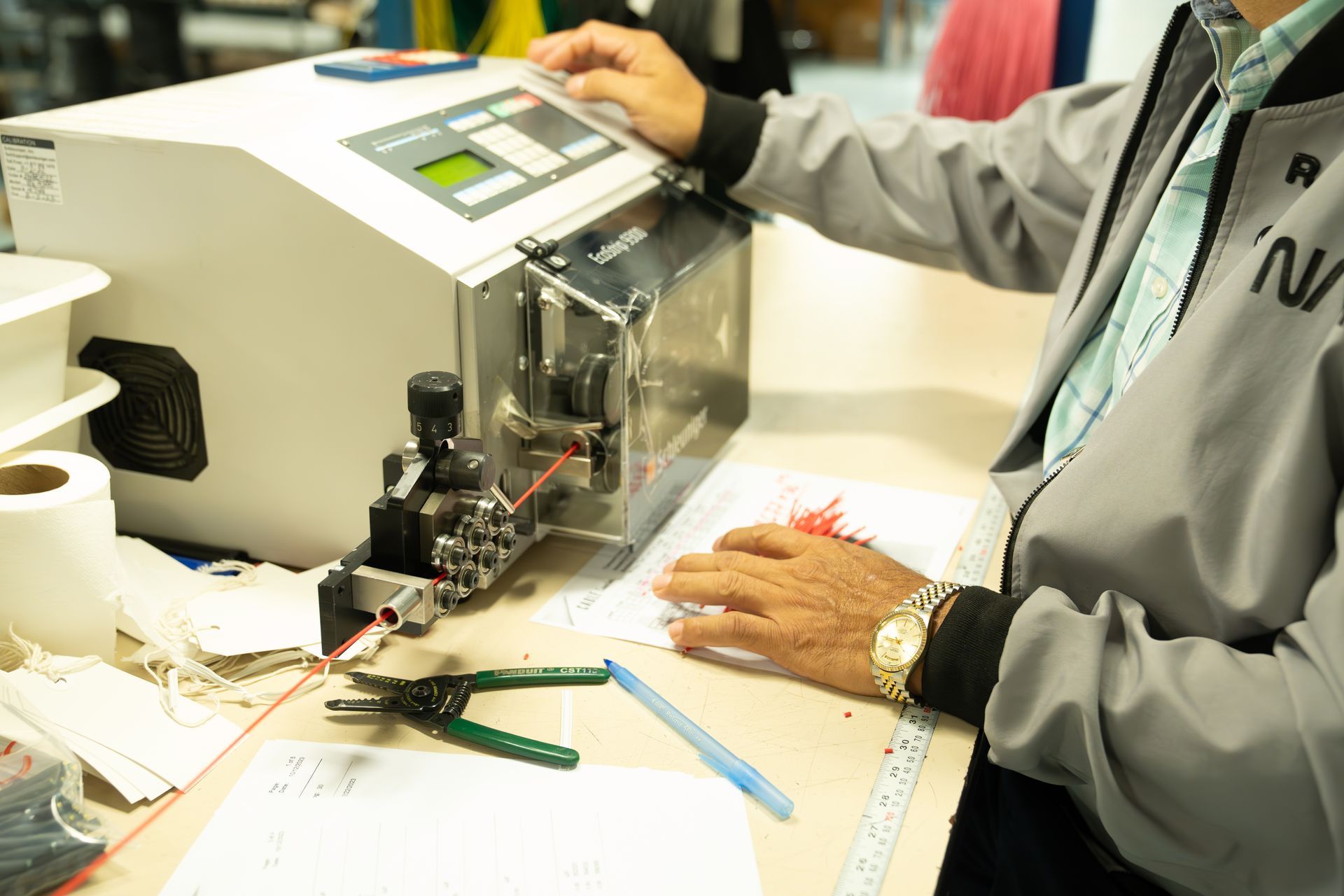 A man is sitting at a table working on a machine.
