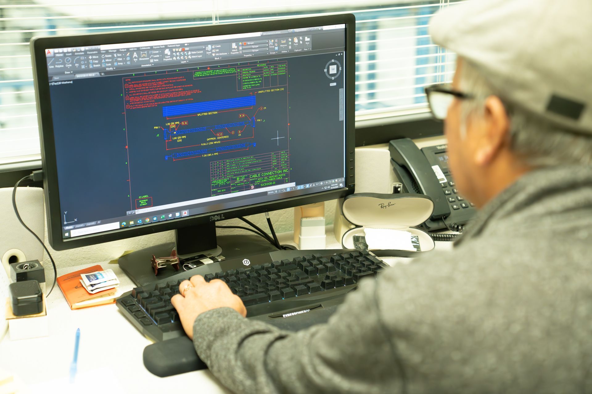 A man is sitting at a desk using a computer.