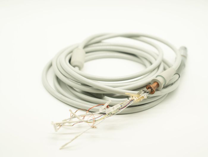 A close up of a cable with a copper connector on a white surface.