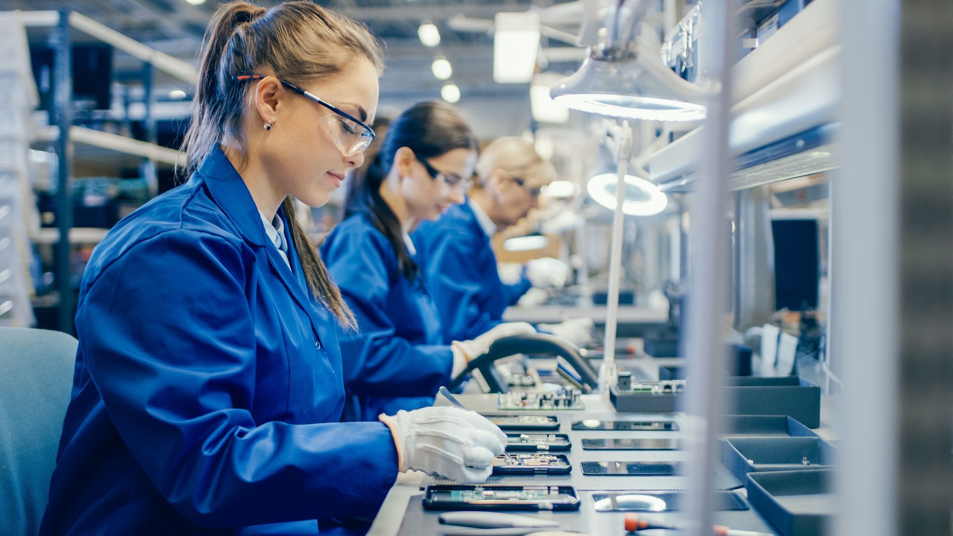 A group of women are working on a conveyor belt in a factory.