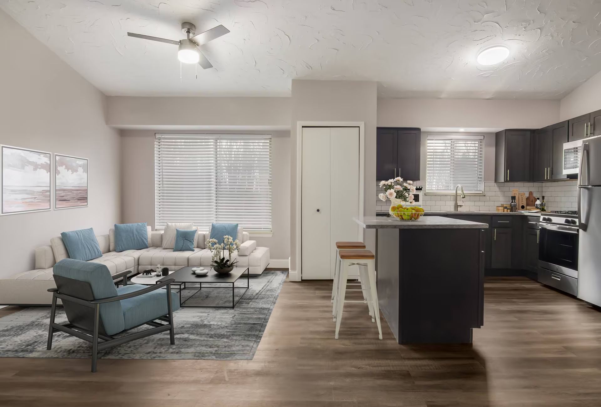 Modern apartment interior with living room, kitchen, island, and wood-look flooring.