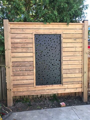 A wooden fence with a window in the middle of it.