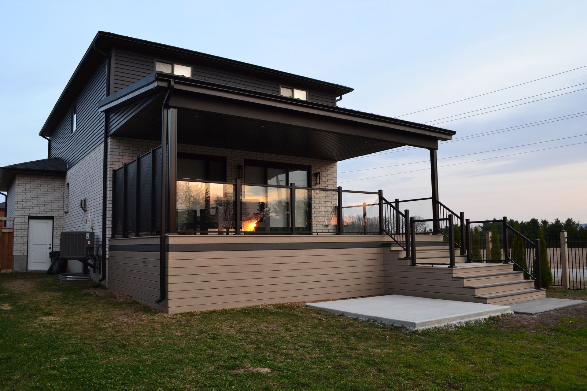 The back of a house with a large deck and stairs.