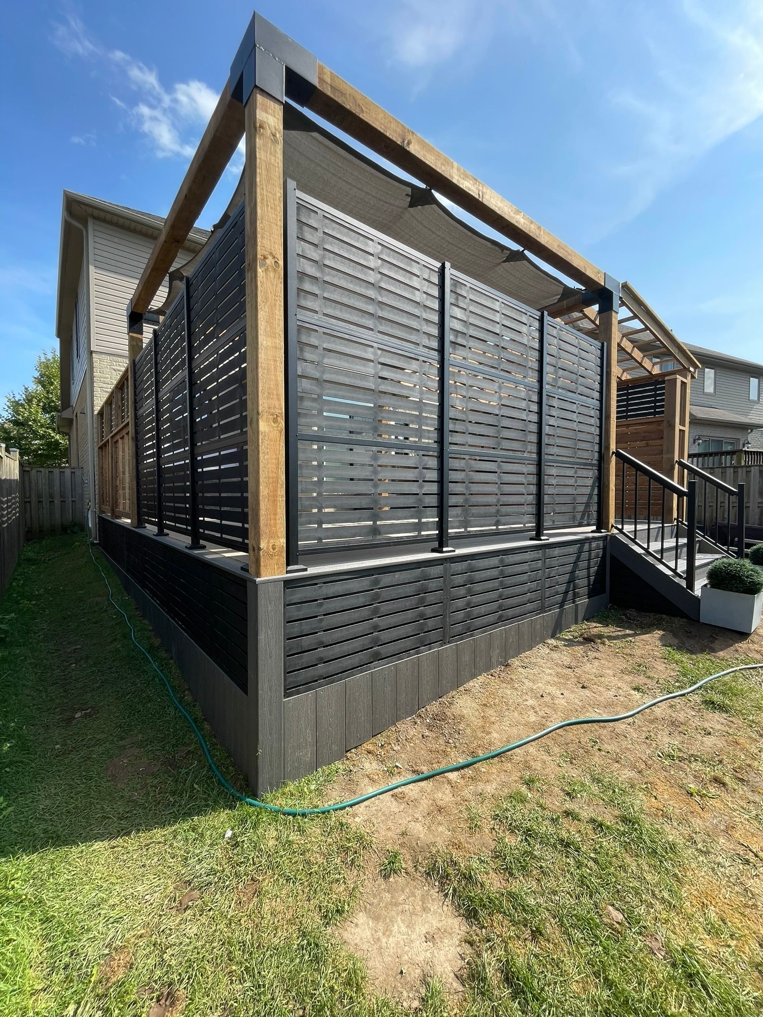A house with a pergola and stairs in the backyard.