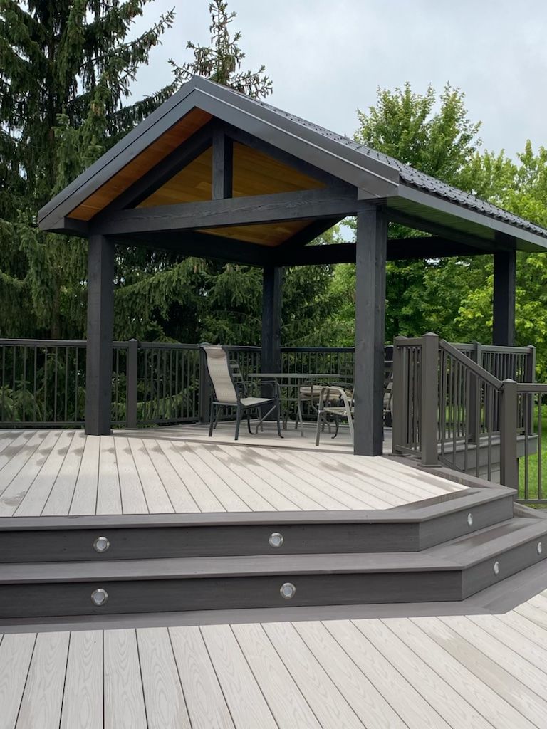 A deck with a gazebo and chairs on it