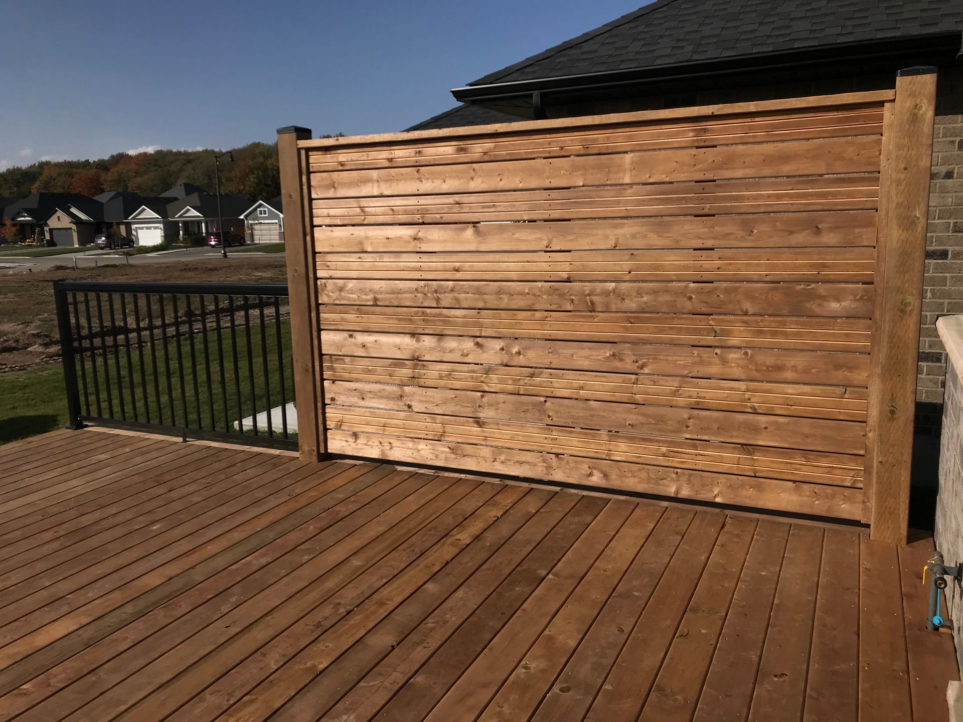 A wooden deck with a wooden fence surrounding it.