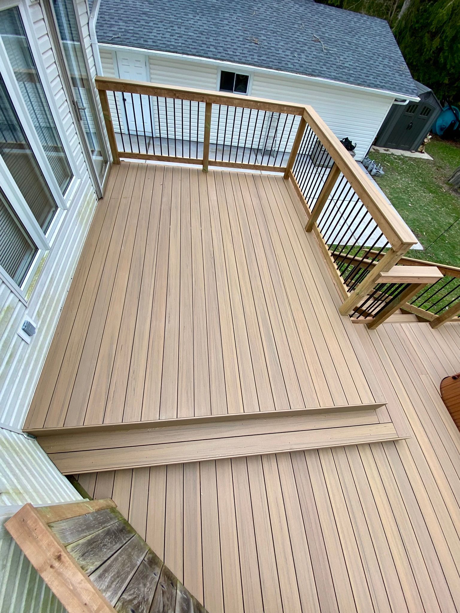 Kitchen and dining area with light wood table, black chairs, and black appliances.