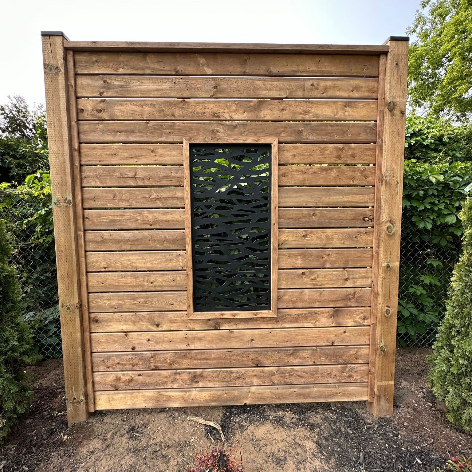 A wooden fence with a window in the middle of it.