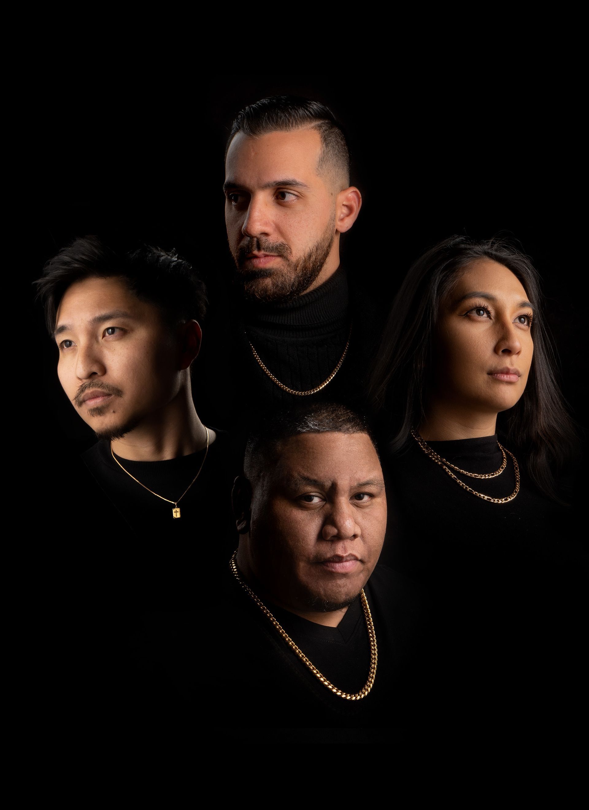 a group of people wearing black shirts and gold chains are posing for a picture .