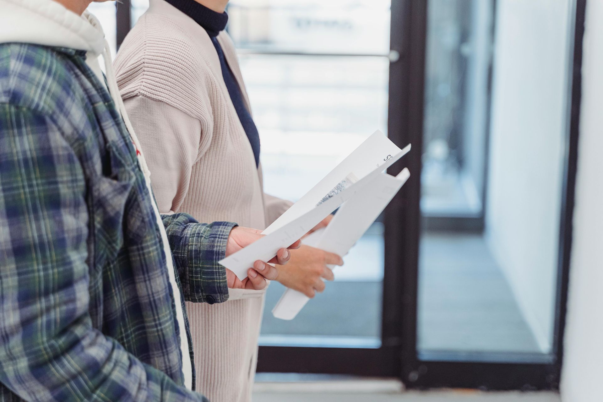 A man and a woman are standing next to each other holding papers.