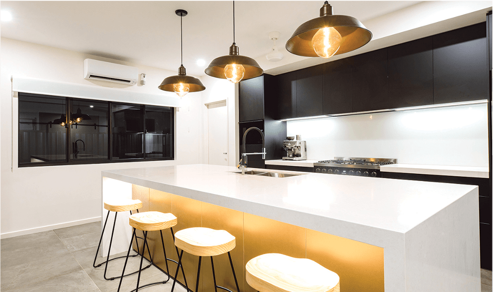 Modern kitchen with black cabinets, white countertop, pendant lights, and bar stools.