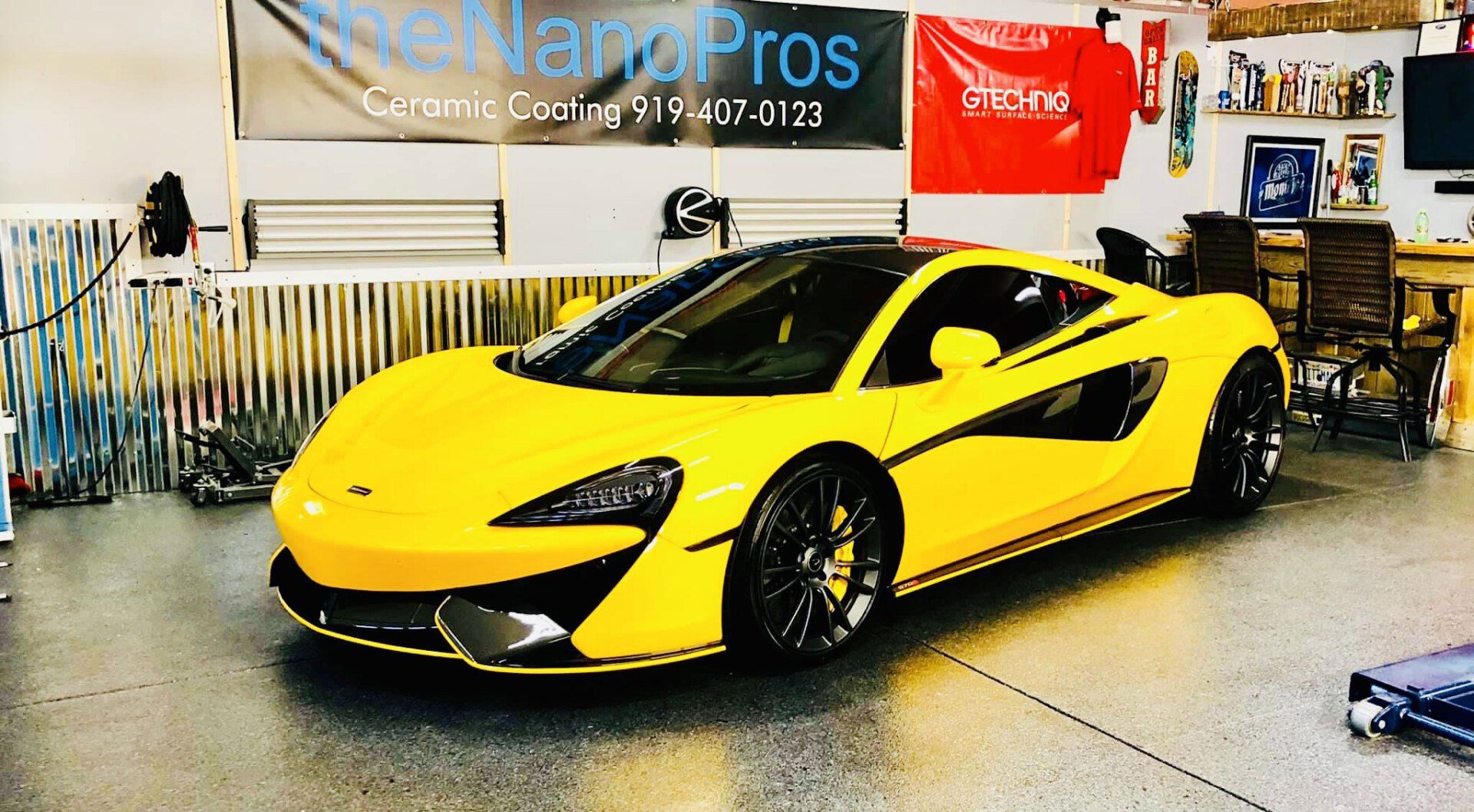 A yellow sports car is parked in a garage.