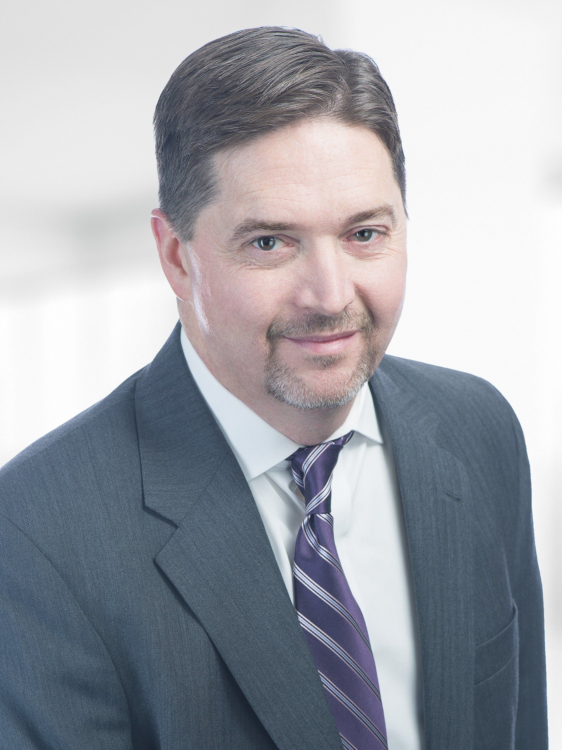 A man in a suit and tie is smiling for the camera.