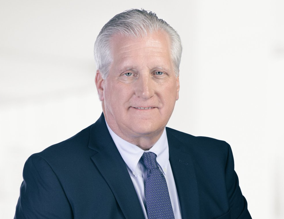 A man in a suit and tie is smiling for the camera.