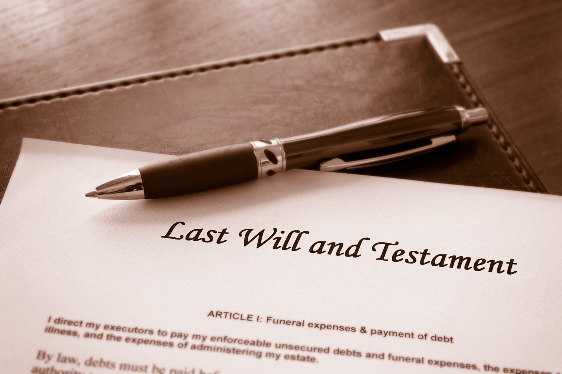 A pen is sitting on top of a last will and testament