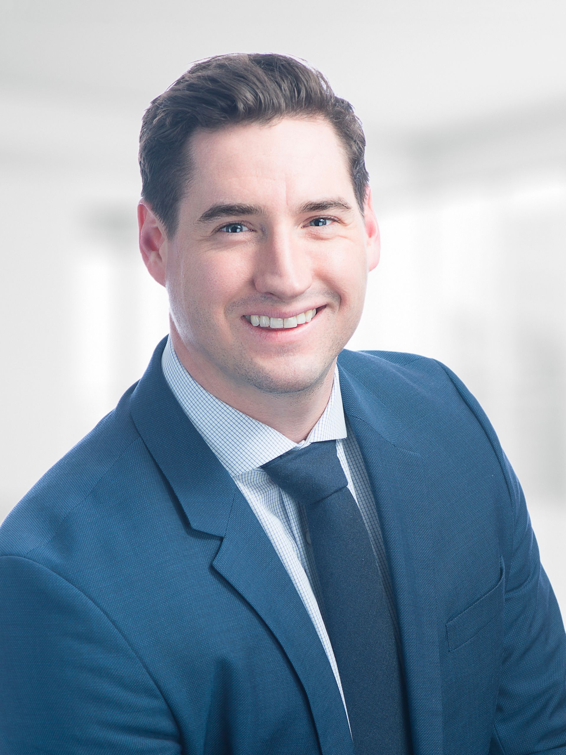 A man in a suit and tie is smiling for the camera.