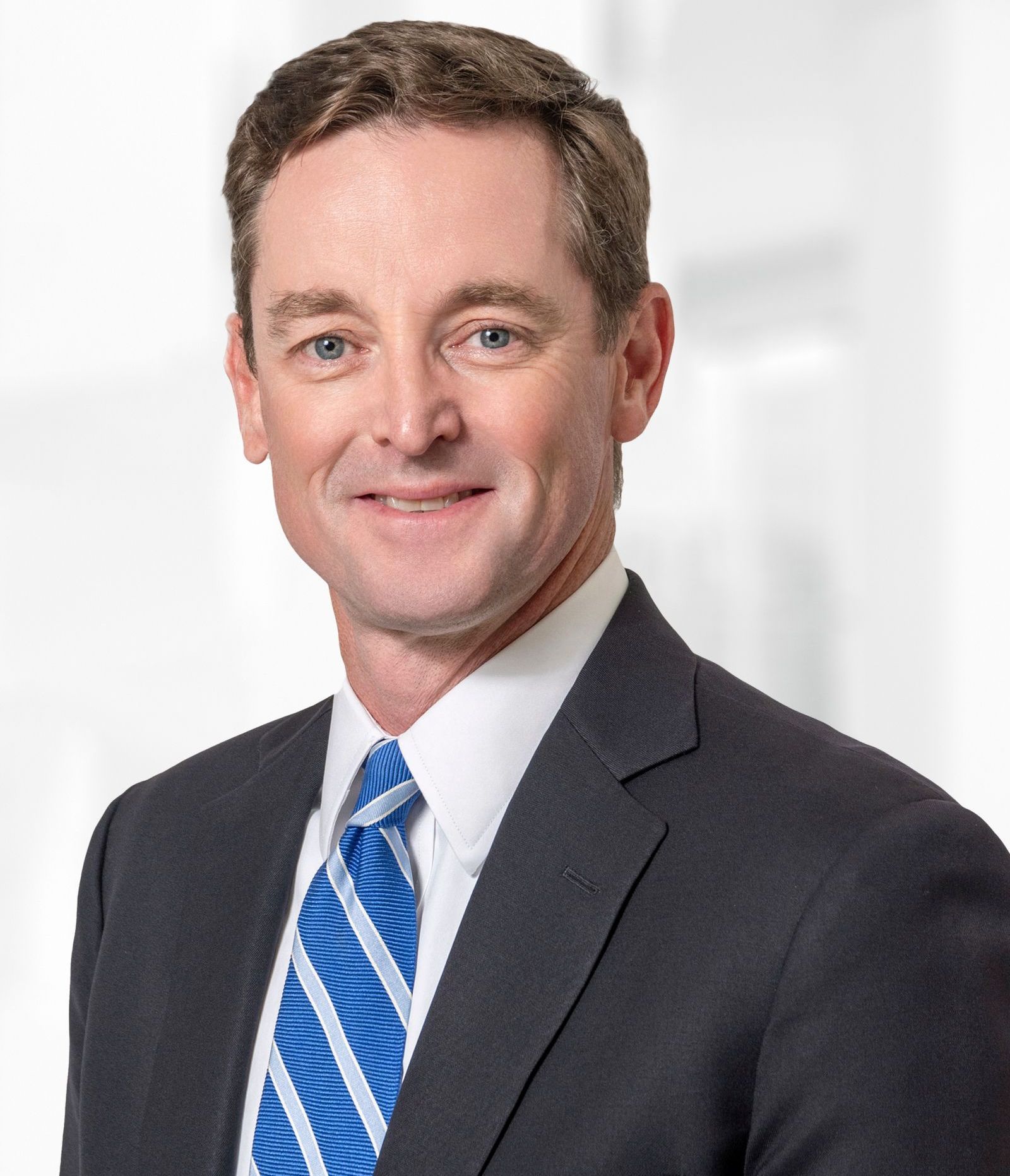 A man in a suit and tie is smiling for the camera