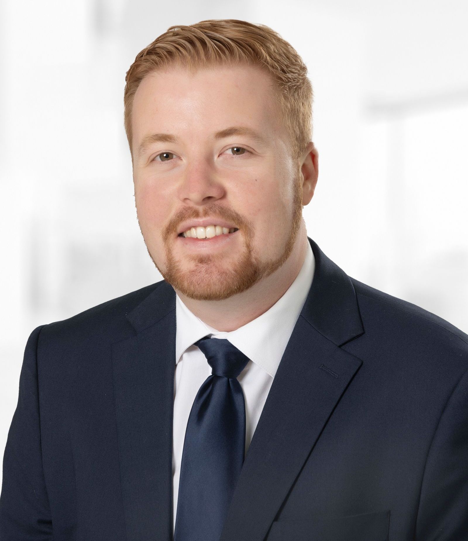 A man in a suit and tie is smiling for the camera.
