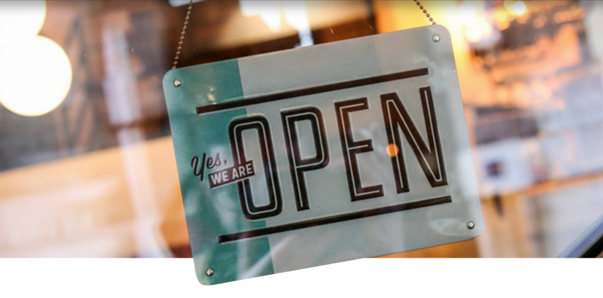 A close up of an open sign hanging on a window.