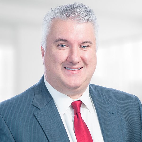 A man in a suit and tie is smiling for the camera.