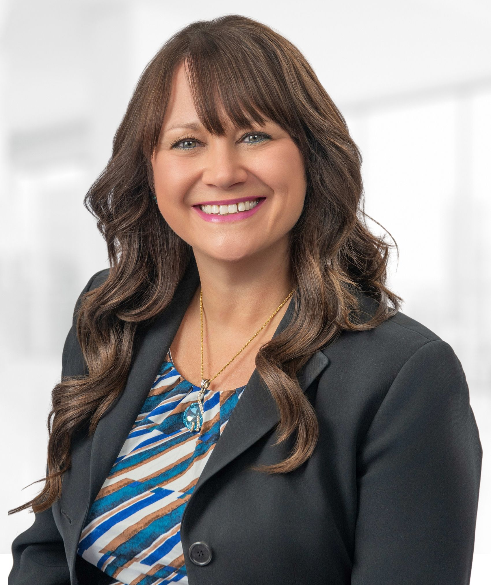 A woman in a black jacket is smiling for the camera