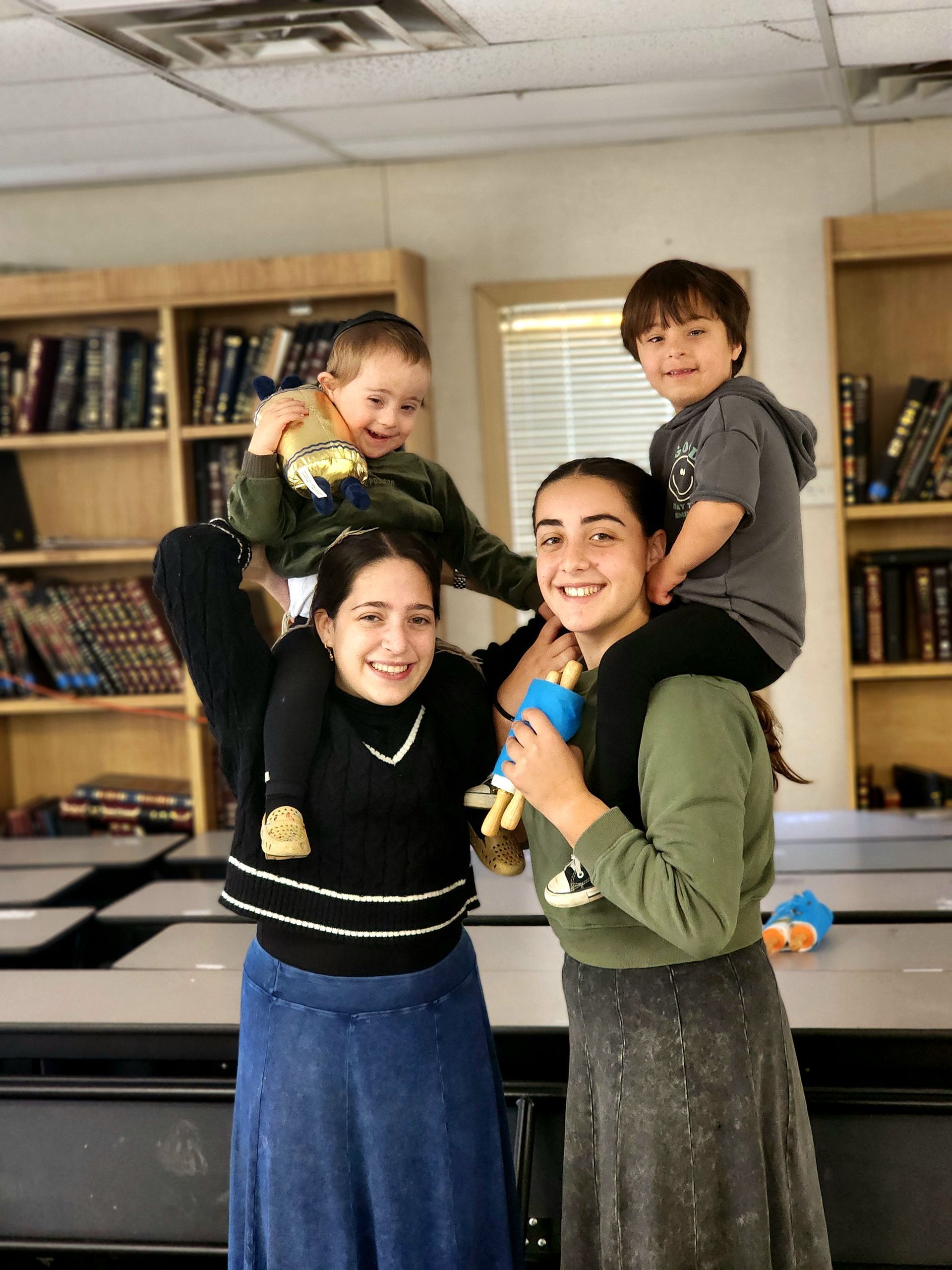 A woman is carrying two children on her shoulders