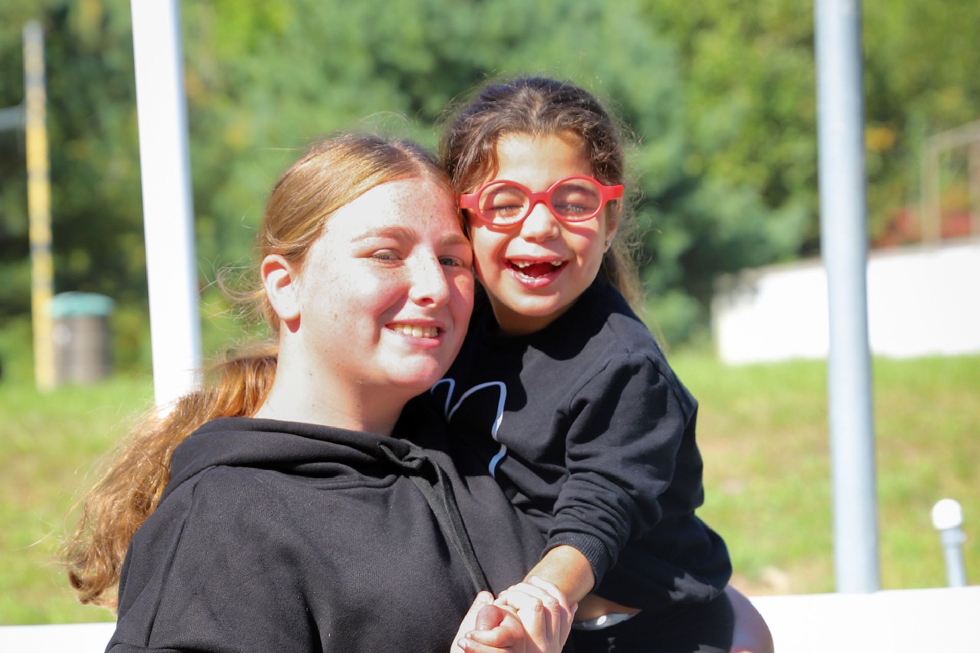 A woman is holding a little girl in her arms.