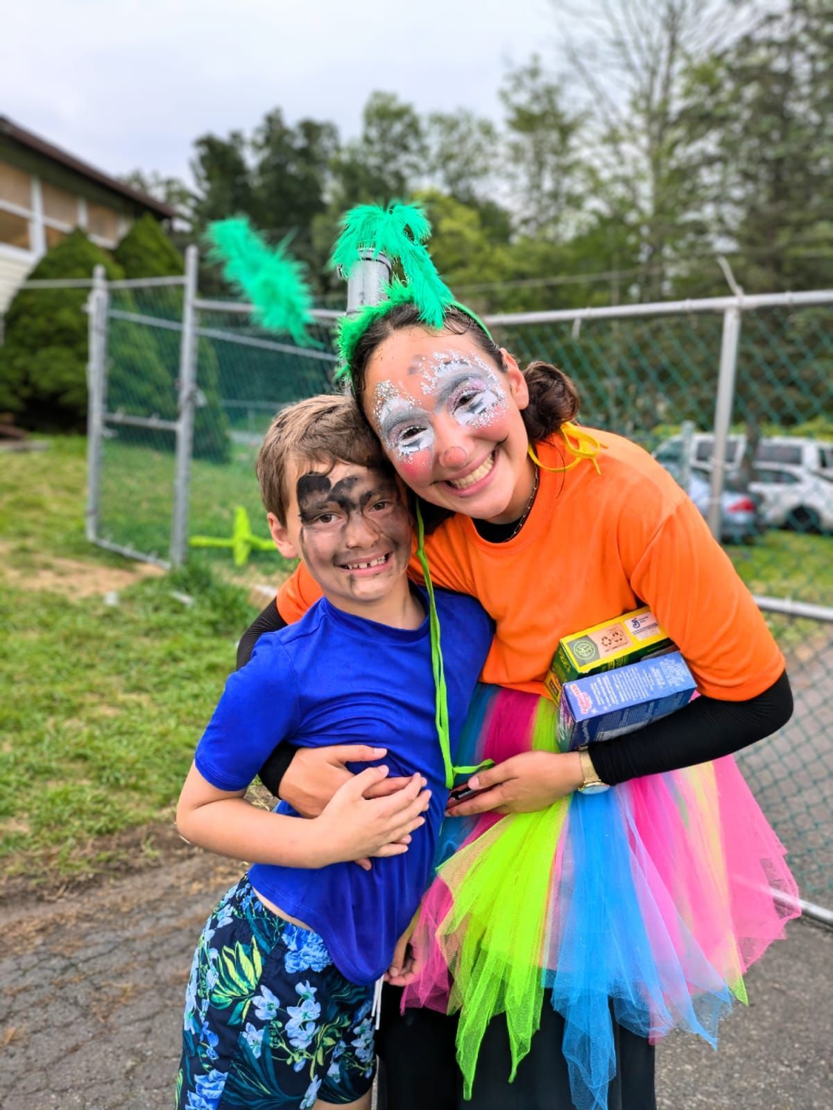 A woman is hugging a boy with face paint on his face.